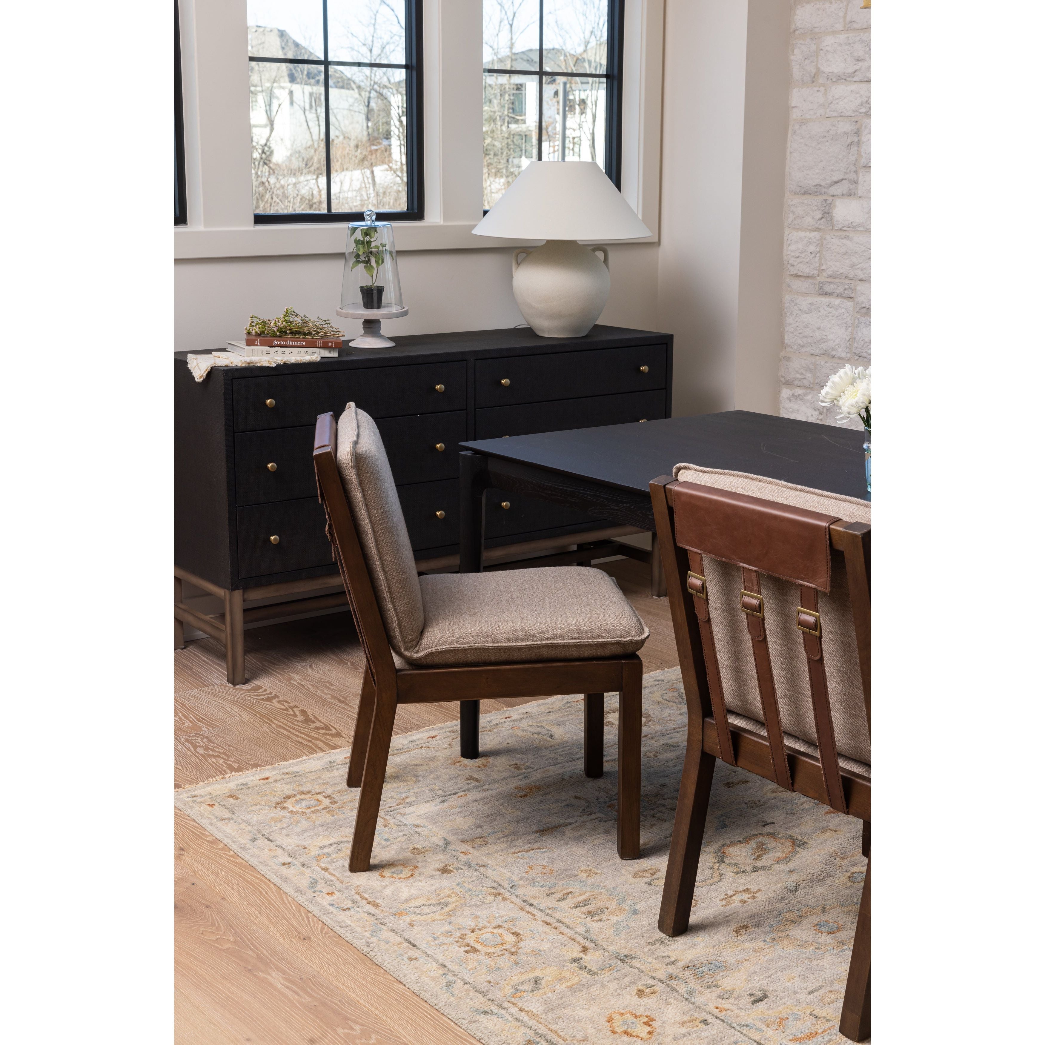 Featuring Wilmington Alcala Fawn Dining Chair by Four Hands at Amethyst Home. An Amethyst fave -- the Wilmington dining chair has a gorgeous coffee colored textile paired with medium toned wood and interesting leather buckles on the back -- we tied in the gold buckles with the gold chandelier above!  Inspired by the folded pillow form, the seat and back cu. Amethyst Home provides interior design, new home construction design consulting, vintage area rugs, and lighting in the Washington metro area.