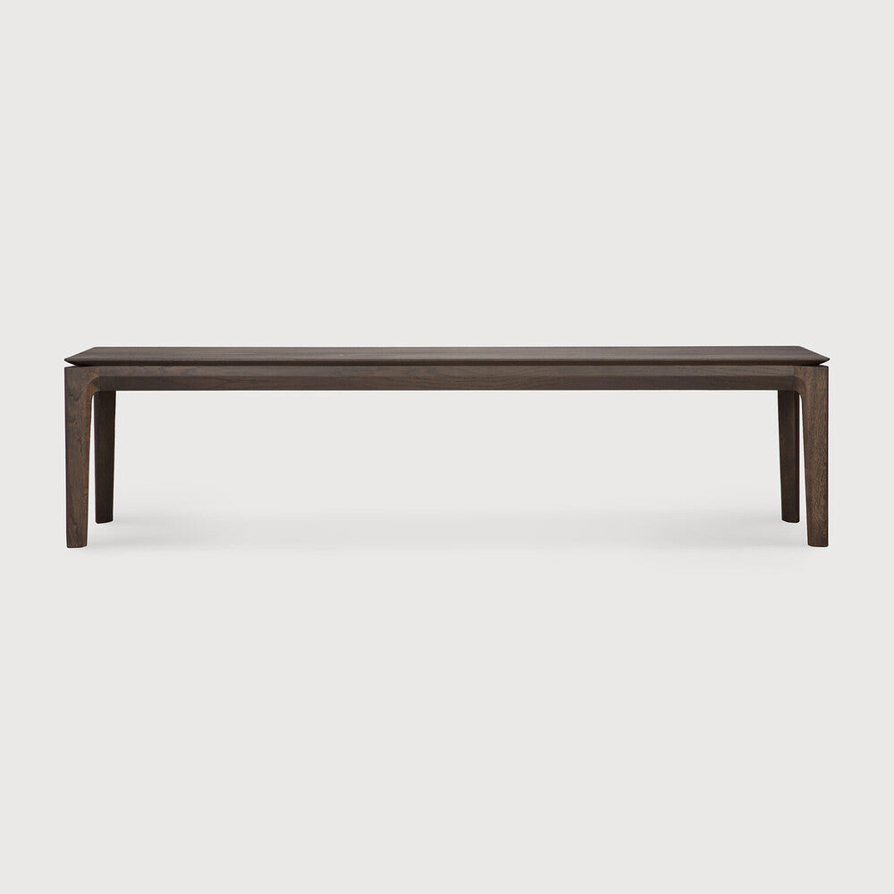 Featuring Bok Oak Brown Bench by Ethnicraft at Amethyst Home. Reminiscent of a goat's curved horns, the Bok collection combines sculptural elegance and contemporary crafting into a graceful and airy form. The Bok bench pairs well with the Bok dining table, but also as a stand-alone against a wall, in a hallway or at the end of a bed.Collection : BokFinish : VarnishedFloor Prot. Amethyst Home provides interior design, new construction, custom furniture, and area rugs in the Newport Beach metro area