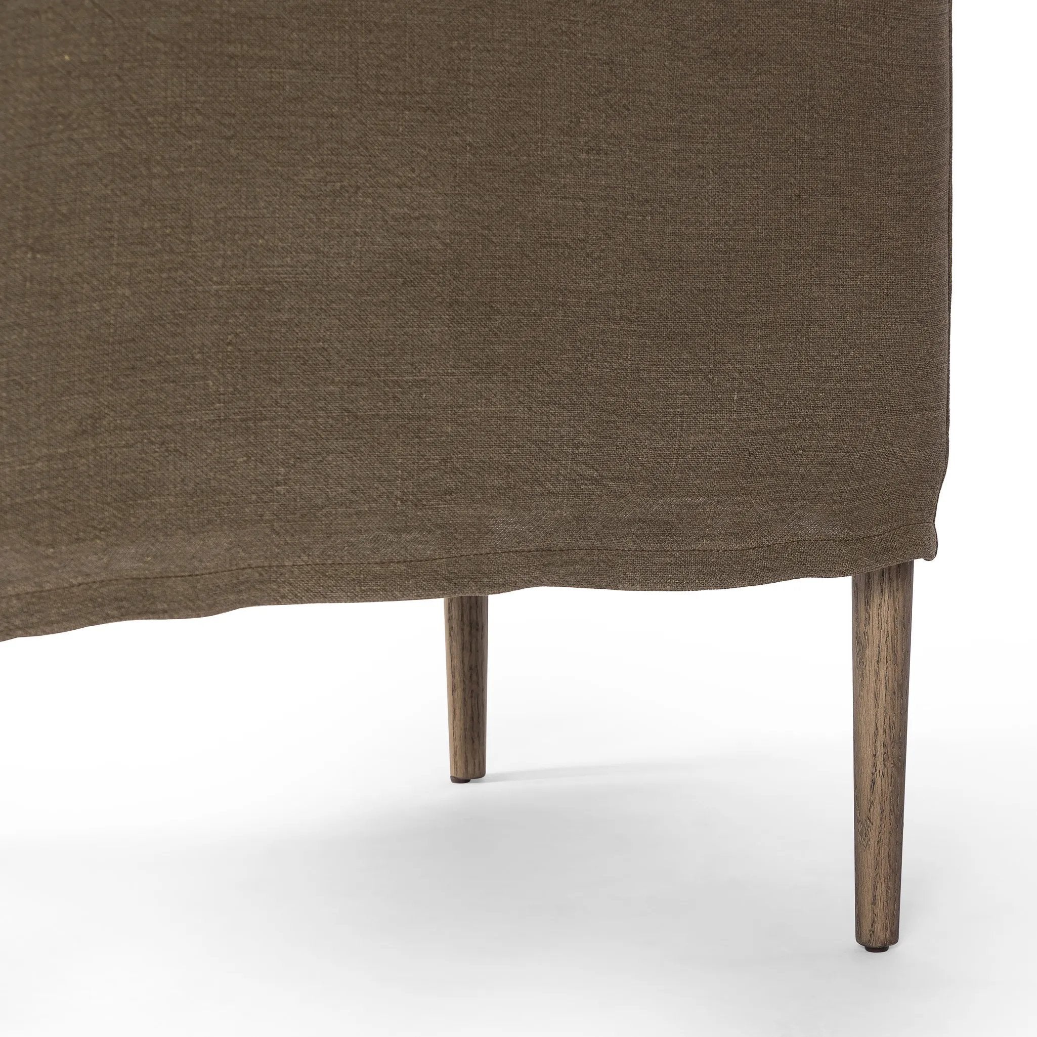Heritage-inspired comfort. Sloping track arms are a study in playful forms, while the frame's fluid shape creates a simple, polished look. Tapered legs extend beyond a short skirt for a more relaxed style. Covered in 100% linen. A design collaboration by Amber Lewis and Four Hands. Amethyst Home provides interior design, new home construction design consulting, vintage area rugs, and lighting in the Laguna Beach metro area.