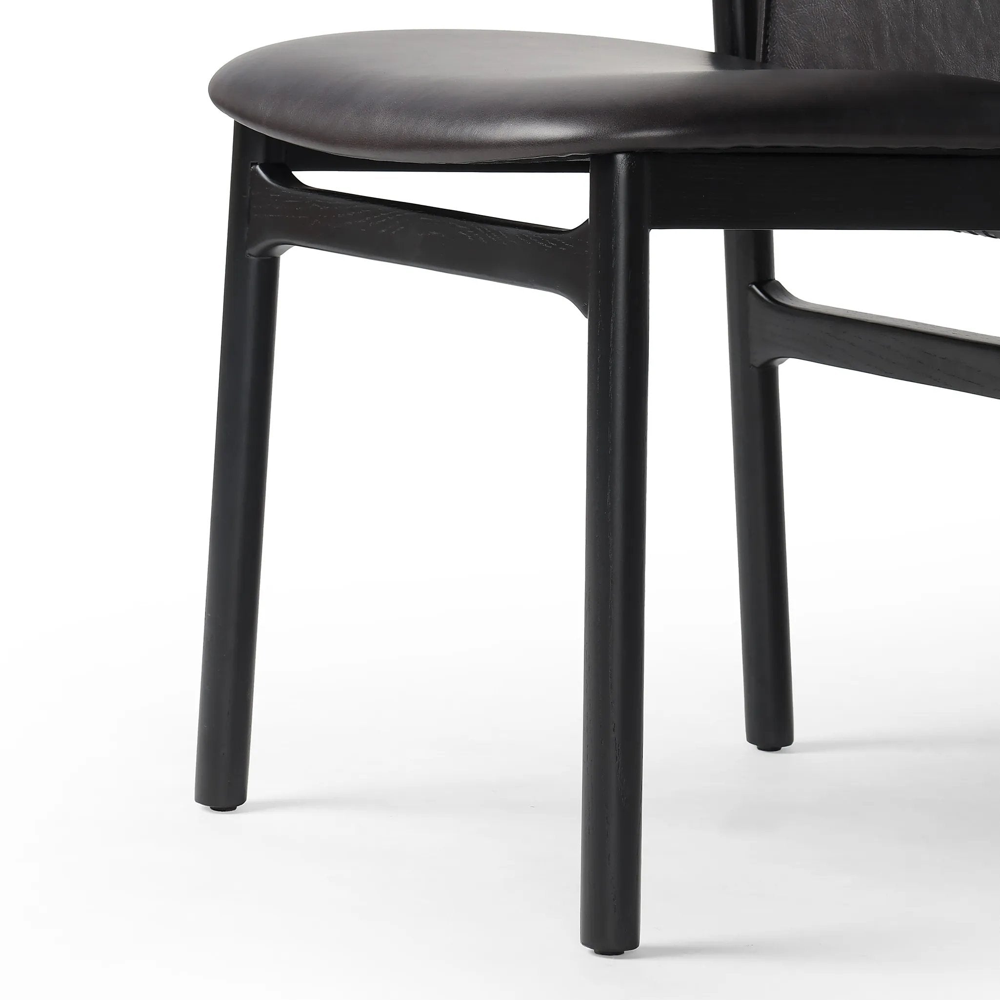 Featuring Baden Sonoma Black Dining Chair by Four Hands at Amethyst Home. Midcentury-inspired with its minimalist wooden frame, this armless dining chair features a low back and float-like seat upholstered in slightly distressed black top-grain leather exclusive to Four Hands. Leather wrap detailing for texture.Overall Dimensions: 19.75"w x 23.25"d x 32.25"hWe. Amethyst Home provides interior design, new home construction design consulting, vintage area rugs, and lighting in the Boston metro area.