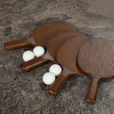 Fun meets flexibility. Two large slabs of warm grey marble, framed in rich oak, join together and sit atop the minimalist plinth bases of this dual-purpose ping pong table. The wooden "net" fastens to the table with custom gunmetal clamps, which can be easily removed for a dining table that seats 12 Amethyst Home provides interior design, new home construction design consulting, vintage area rugs, and lighting in the Newport Beach metro area.