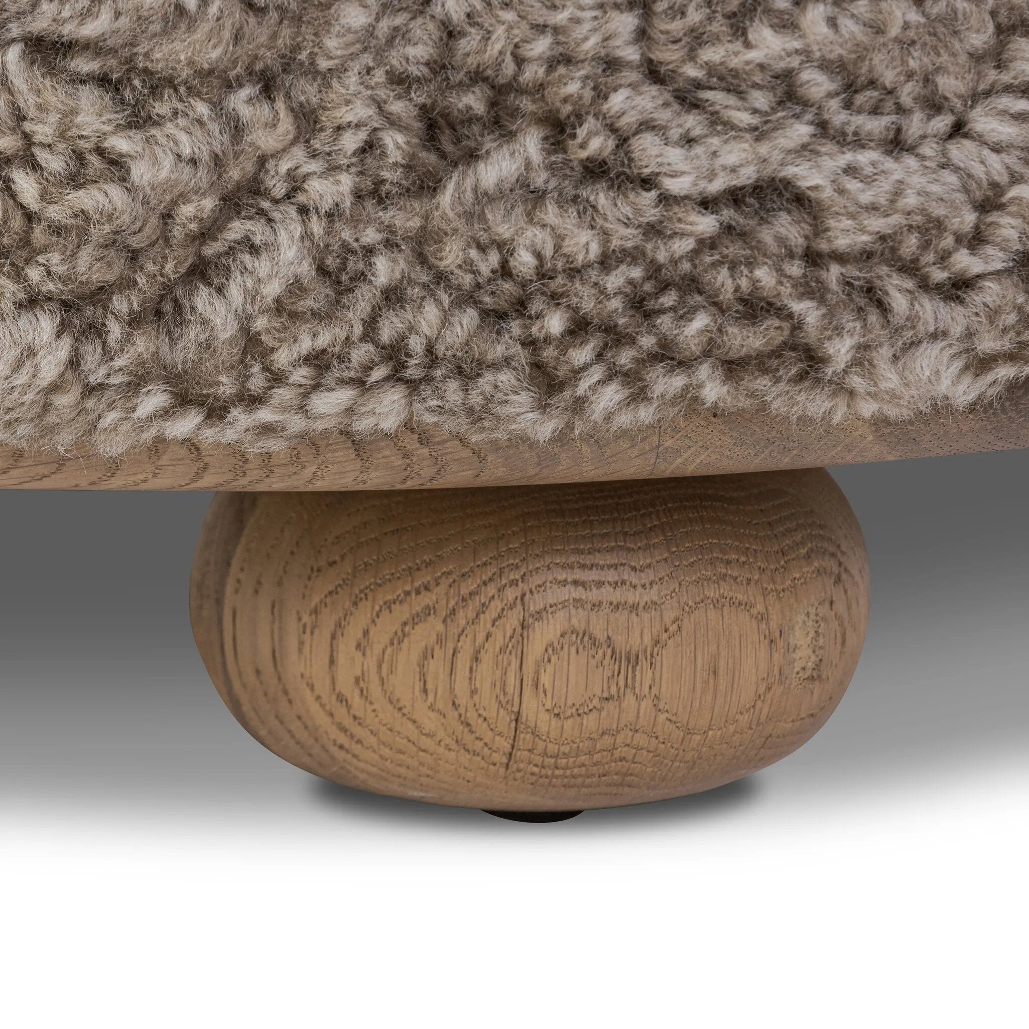 For an extra seat or propped feet, this welcoming ottoman features a subtly tapered shape and a rounded base with bun feet beneath. Crafted from solid oak and upholstered with taupe shearling for extra texture Amethyst Home provides interior design, new home construction design consulting, vintage area rugs, and lighting in the Boston metro area.
