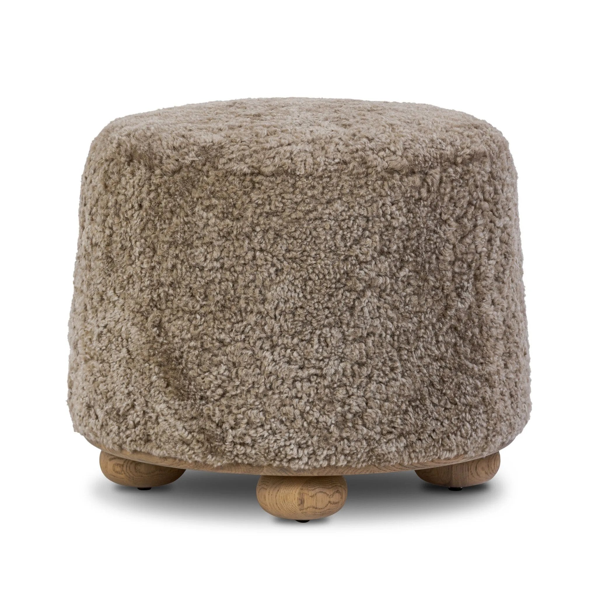 For an extra seat or propped feet, this welcoming ottoman features a subtly tapered shape and a rounded base with bun feet beneath. Crafted from solid oak and upholstered with taupe shearling for extra texture Amethyst Home provides interior design, new home construction design consulting, vintage area rugs, and lighting in the Houston metro area.