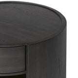 Rich contours bring character to the bedside. A round black-finished oak table has a spacious cubby and a single drawer with metal glides and a bronzed pull Amethyst Home provides interior design, new home construction design consulting, vintage area rugs, and lighting in the Miami metro area.