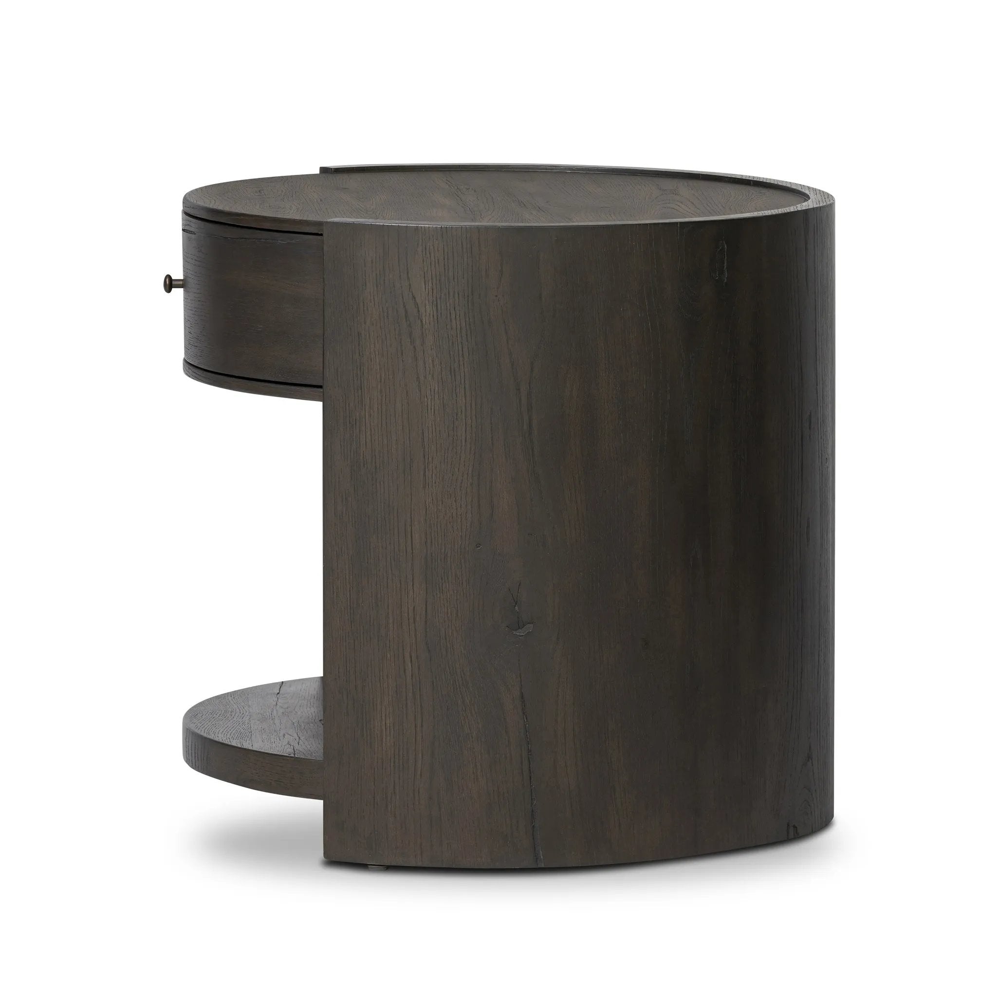 Rich contours bring character to the bedside. A round black-finished oak table has a spacious cubby and a single drawer with metal glides and a bronzed pull Amethyst Home provides interior design, new home construction design consulting, vintage area rugs, and lighting in the Omaha metro area.