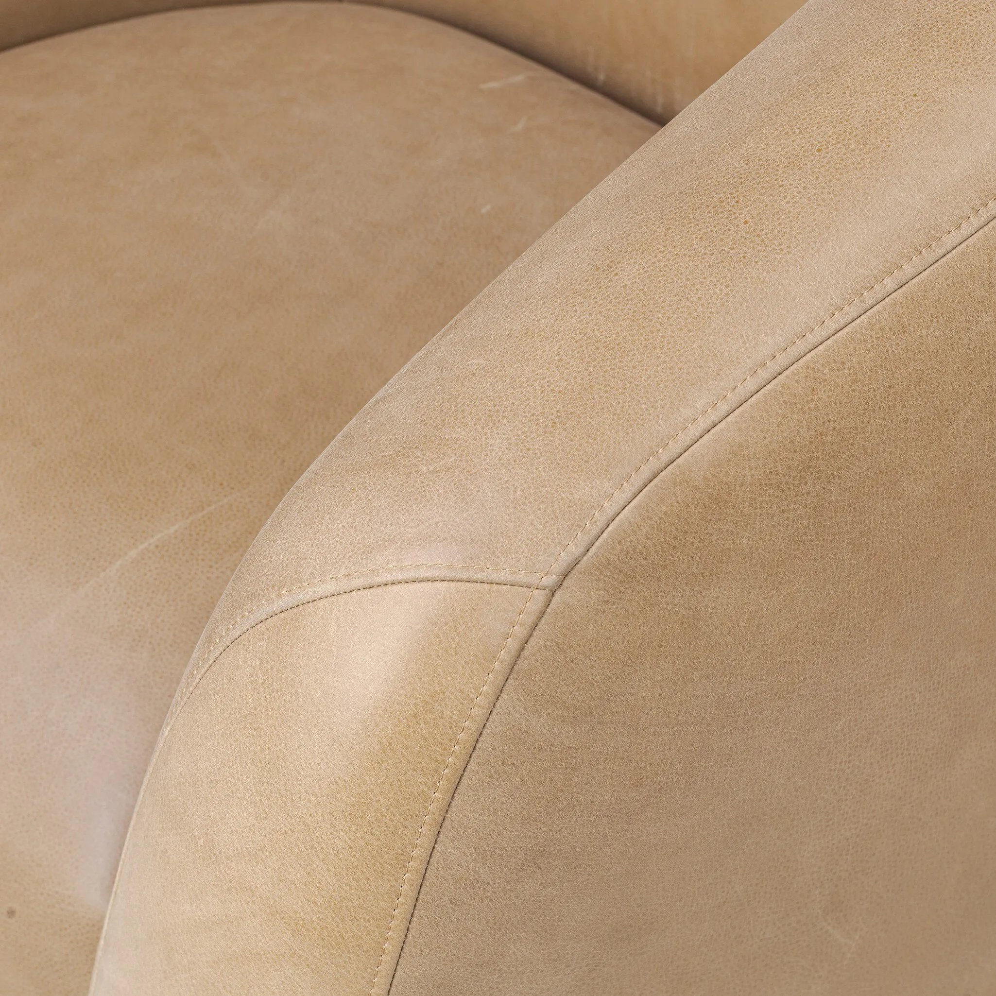 Meet modern comfort. Clean curves, impeccable tailoring and taupe top-grain leather with a pronounced grain bring an elevated, European-inspired look to this swivel chair Amethyst Home provides interior design, new home construction design consulting, vintage area rugs, and lighting in the Omaha metro area.