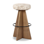 Large angular panels merge to form a geometrically inspired base in this modern counter stool. The circle metal ring around the base serves as a footrest, while the round upholstered cushion provides comfortable seating. The 360-degree swivel function adds versatility, and the combination of wood, metal, and fabric evoke a mixed material moment Amethyst Home provides interior design, new home construction design consulting, vintage area rugs, and lighting in the Scottsdale metro area.