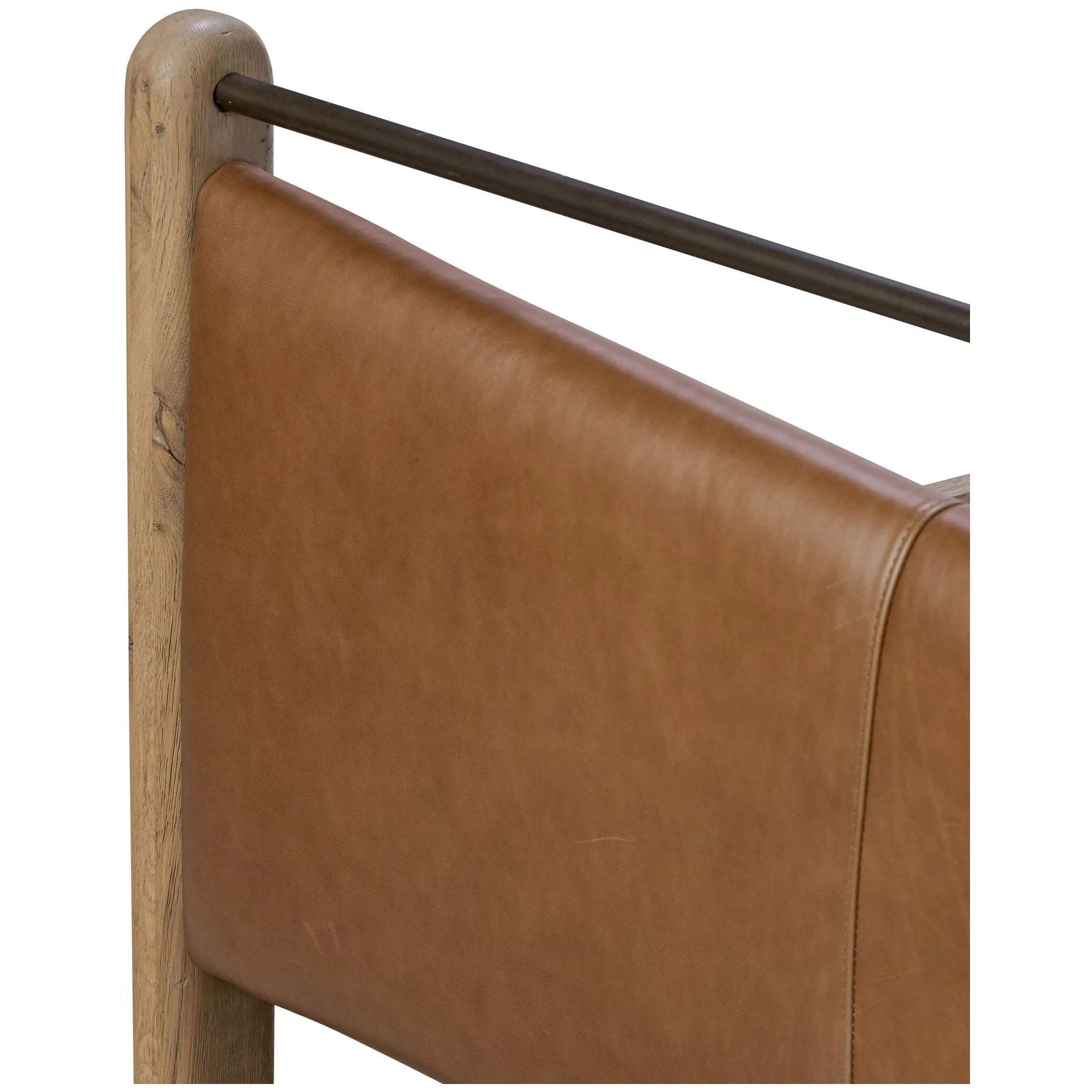 Slightly scooped top-grain leather tufting is bridged with metal bars in brushed brass for modern detailing. Aged smoked oak frames the three-paneled headboard and footboard wrapped in chestnut top-grain leather. Rounded legs soften the look Amethyst Home provides interior design, new home construction design consulting, vintage area rugs, and lighting in the Austin metro area.