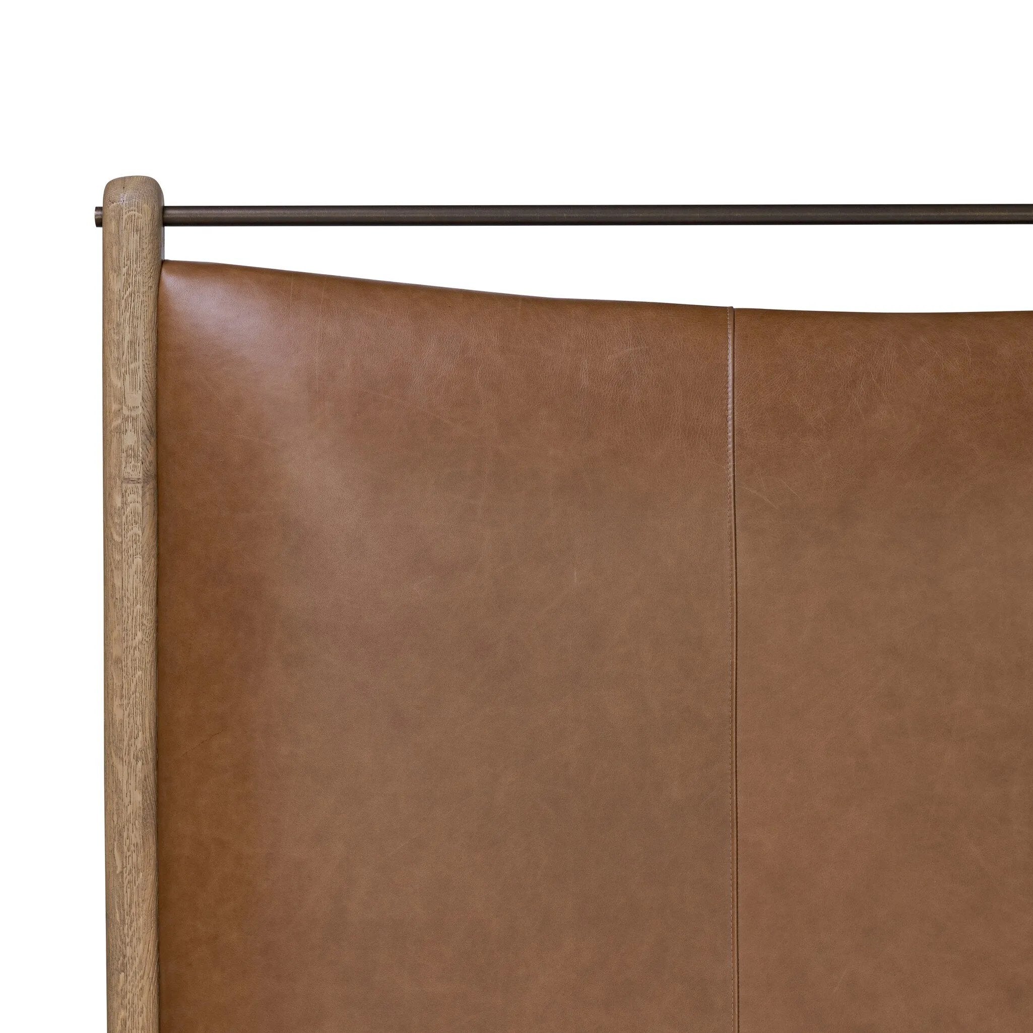 Slightly scooped top-grain leather tufting is bridged with metal bars in brushed brass for modern detailing. Aged smoked oak frames the three-paneled headboard and footboard wrapped in chestnut top-grain leather. Rounded legs soften the look Amethyst Home provides interior design, new home construction design consulting, vintage area rugs, and lighting in the Boston metro area.