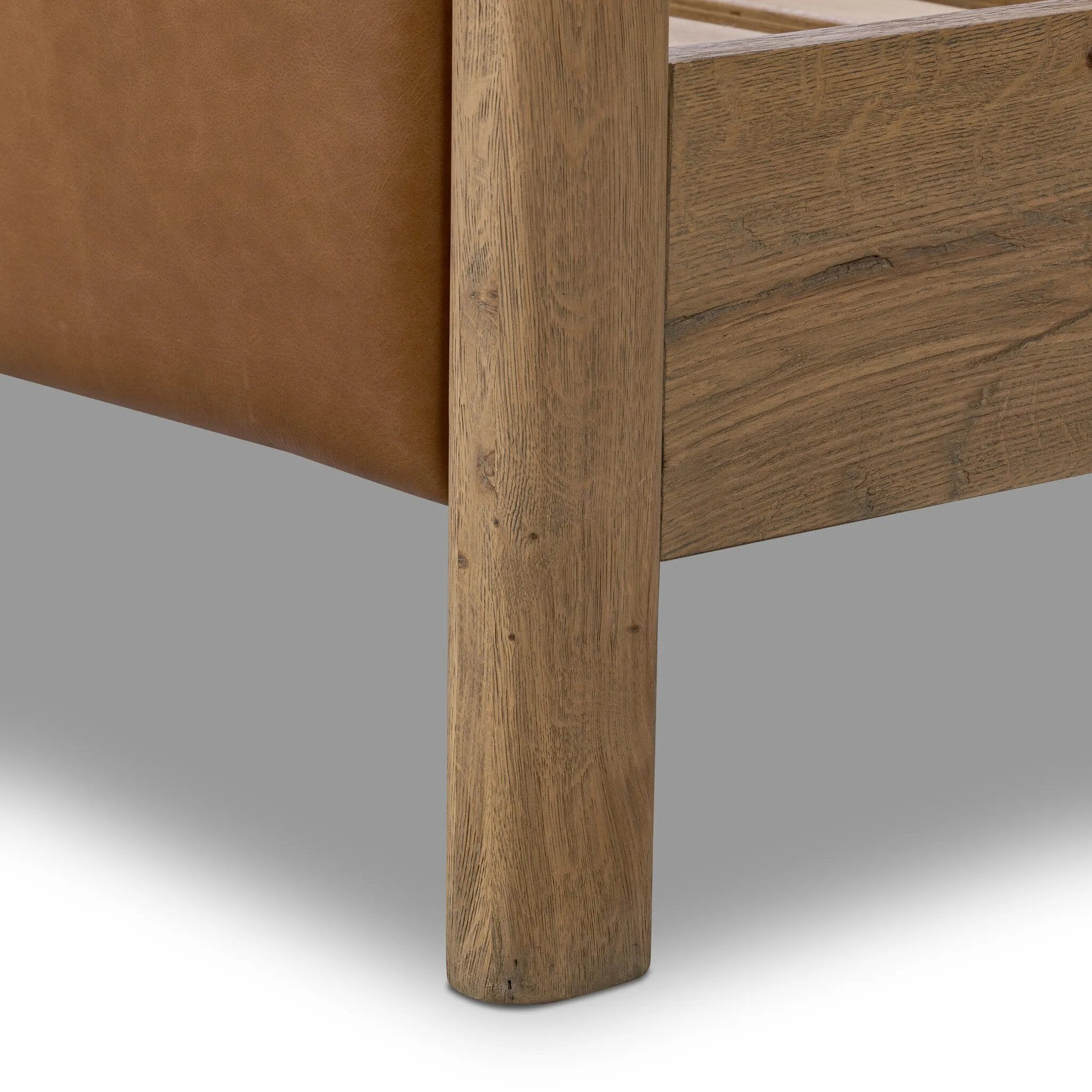 Slightly scooped top-grain leather tufting is bridged with metal bars in brushed brass for modern detailing. Aged smoked oak frames the three-paneled headboard and footboard wrapped in chestnut top-grain leather. Rounded legs soften the look Amethyst Home provides interior design, new home construction design consulting, vintage area rugs, and lighting in the Dallas metro area.