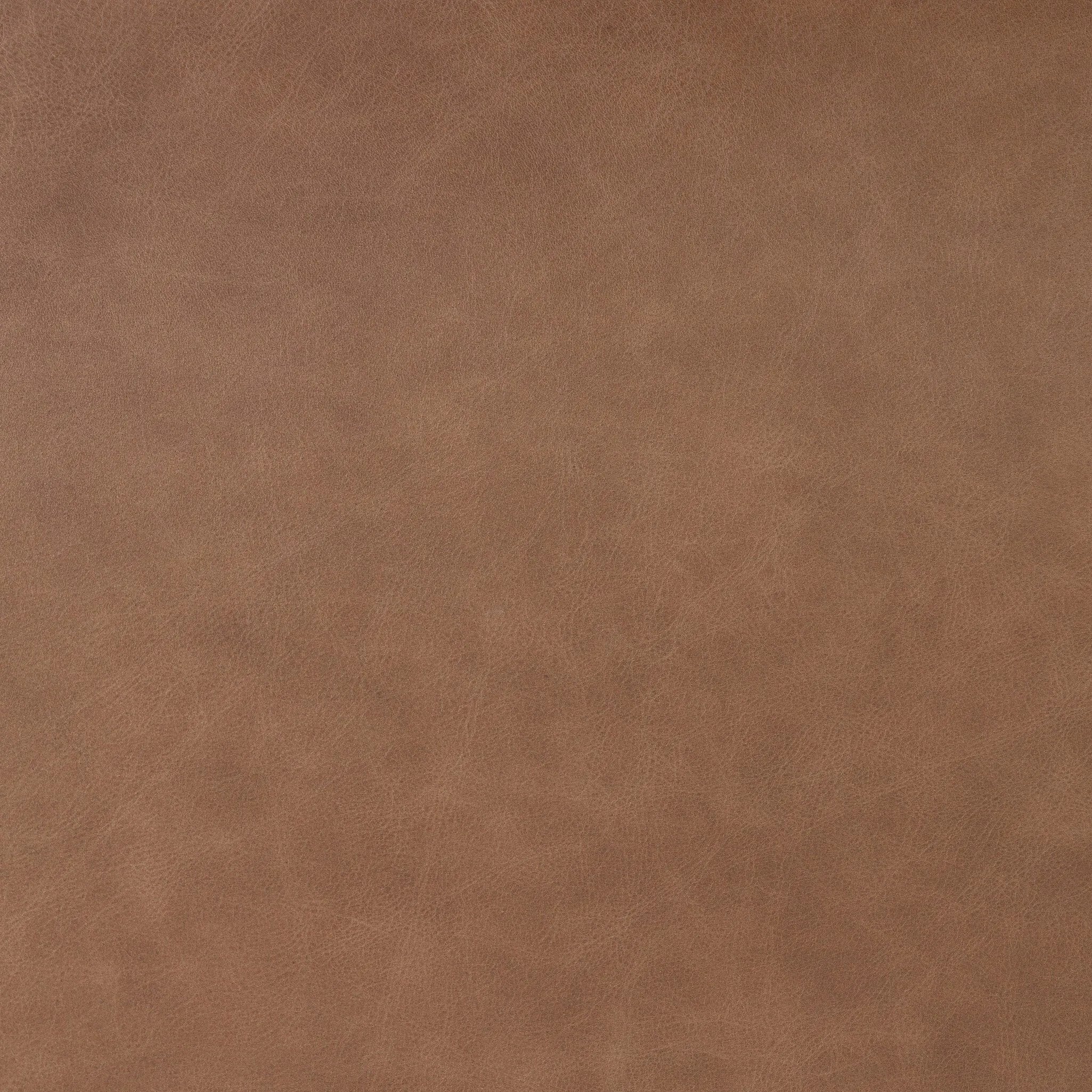 Slightly scooped top-grain leather tufting is bridged with metal bars in brushed brass for modern detailing. Aged smoked oak