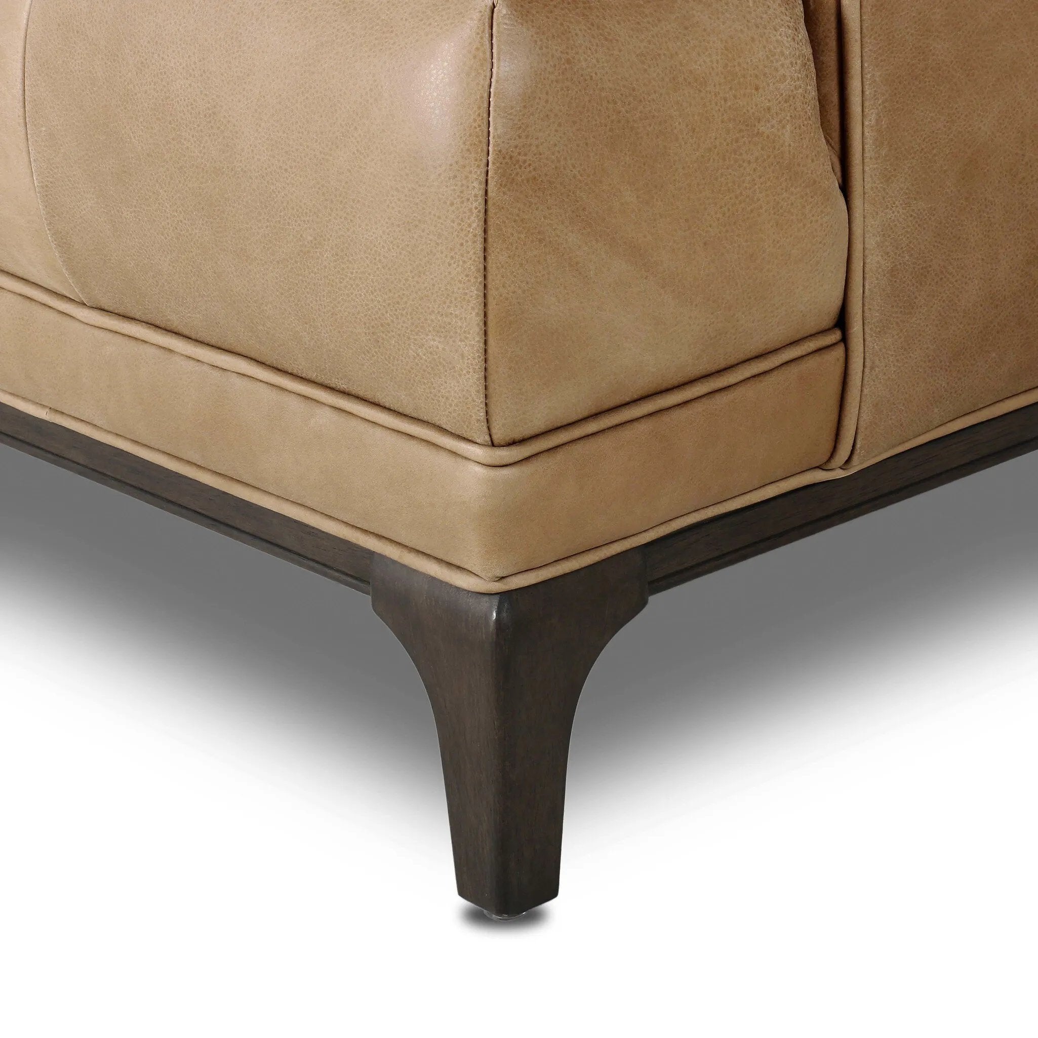 A modernized midcentury silhouette meets the traditional Chesterfield sofa, all in a compact profile perfect for smaller spaces. Top-grain leather in a tan hue, button tufting and a smooth touch bring deep comfort to lounging Amethyst Home provides interior design, new home construction design consulting, vintage area rugs, and lighting in the Kansas City metro area.