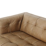 A modernized midcentury silhouette meets the traditional Chesterfield sofa, all in a compact profile perfect for smaller spaces. Top-grain leather in a tan hue, button tufting and a smooth touch bring deep comfort to lounging Amethyst Home provides interior design, new home construction design consulting, vintage area rugs, and lighting in the Nashville metro area.