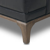 A modernized midcentury silhouette meets the traditional Chesterfield sofa, all in a compact profile perfect for smaller spaces. Top-grain leather in a classic black, button tufting and a smooth touch bring deep comfort to lounging Amethyst Home provides interior design, new home construction design consulting, vintage area rugs, and lighting in the Austin metro area.