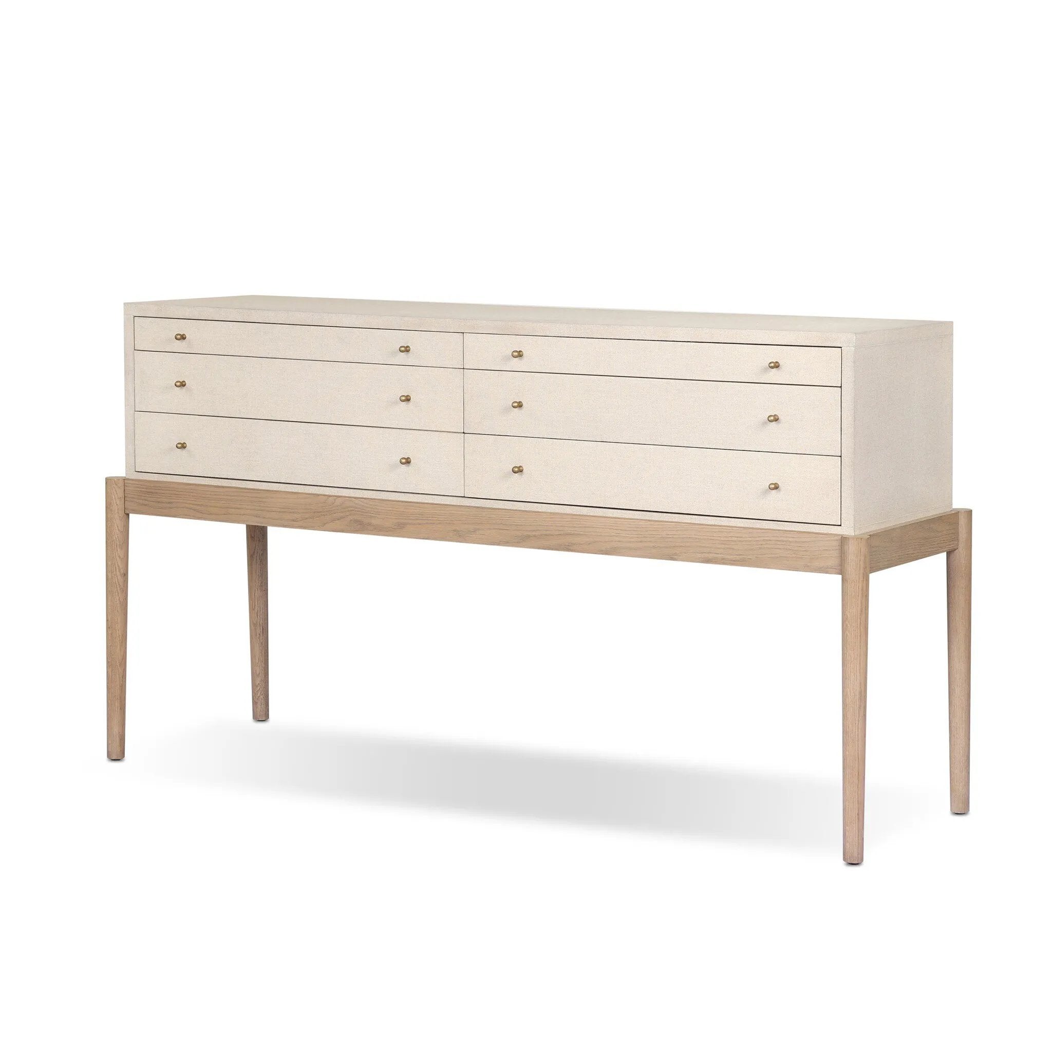 A soft statement console table with ample storage, inspired by a dresser silhouette. The elevated case is wrapped in painted linen and sits atop an oak base for a light and airy look Amethyst Home provides interior design, new home construction design consulting, vintage area rugs, and lighting in the Austin metro area.