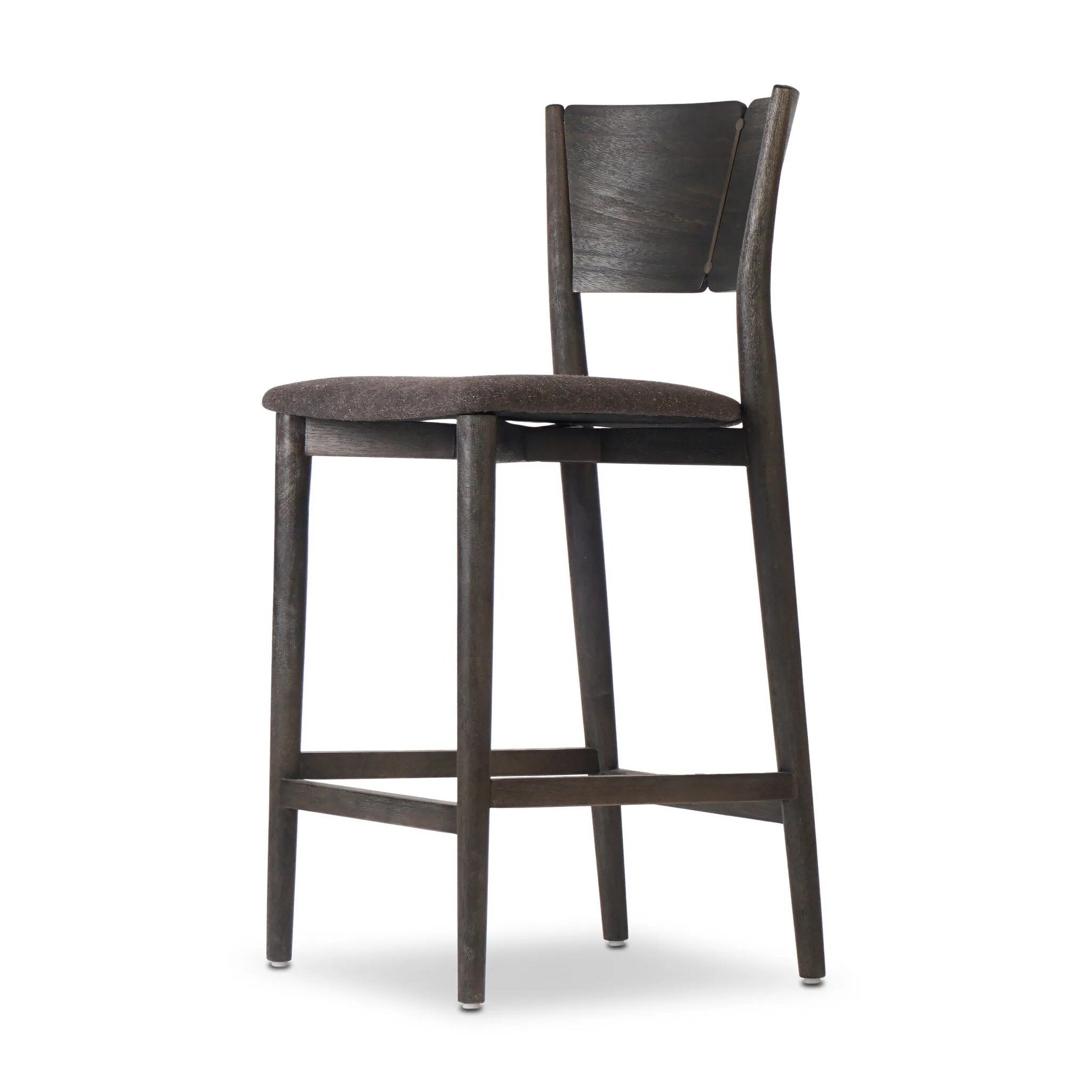 Inspired by simple Scandinavian styling, a dark-finished parawood stool's slit-back metal inlay adds a decorative touch. Easy curves from bent wood give a smooth silhouette. Sized for the counter and upholstered with a thin seat cushion upholstered in black performance fabric, perfect for dining or entertaining. Amethyst Home provides interior design, new home construction design consulting, vintage area rugs, and lighting in the Nashville metro area.
