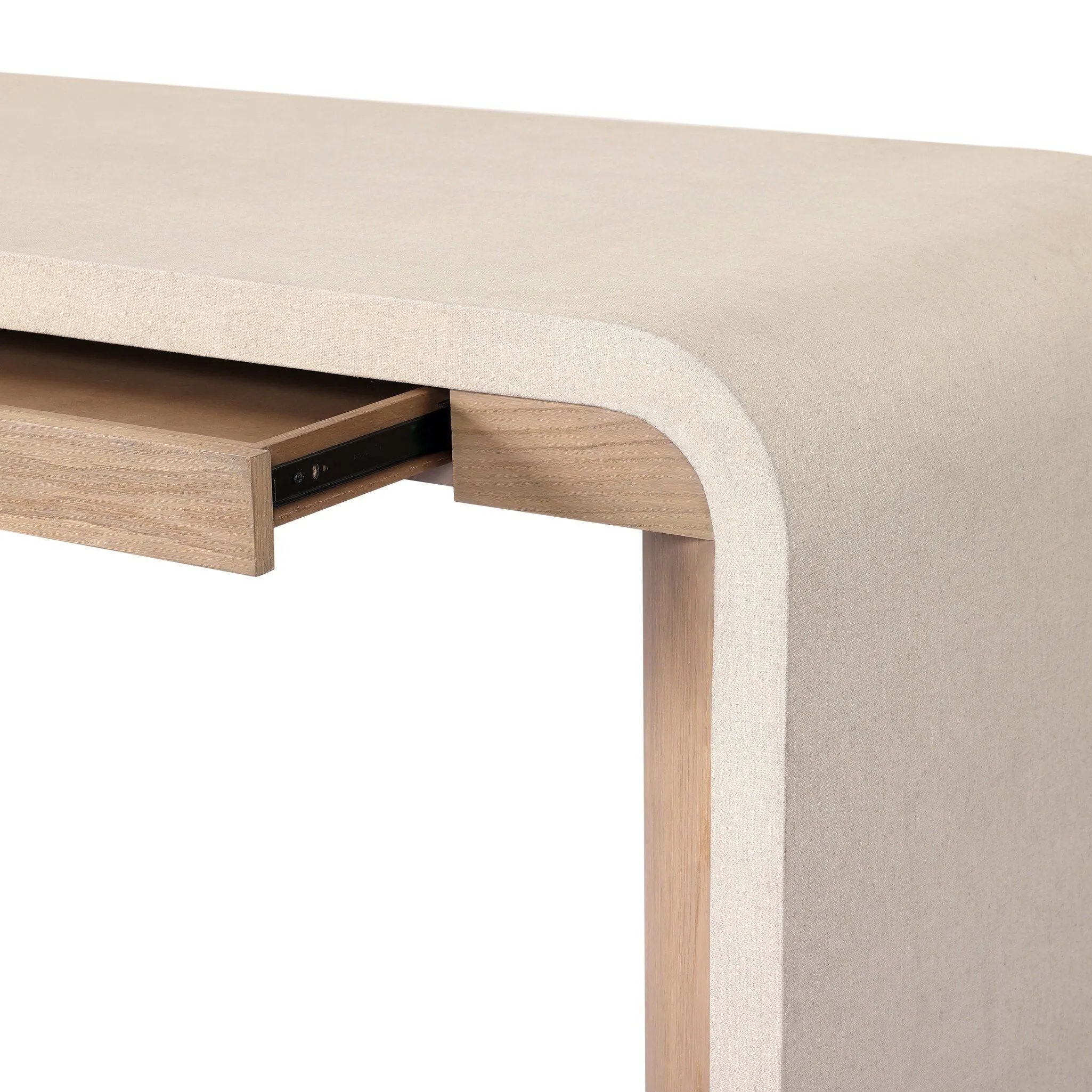 A thick layer of beige painted linen cascades this desk's soft waterfall shape in an eye-catching combination of texture. Crafted atop a mahogany and oak veneer base with rounded corners, this hardworking piece elevates the home-office workspace Amethyst Home provides interior design, new home construction design consulting, vintage area rugs, and lighting in the Newport Beach metro area.