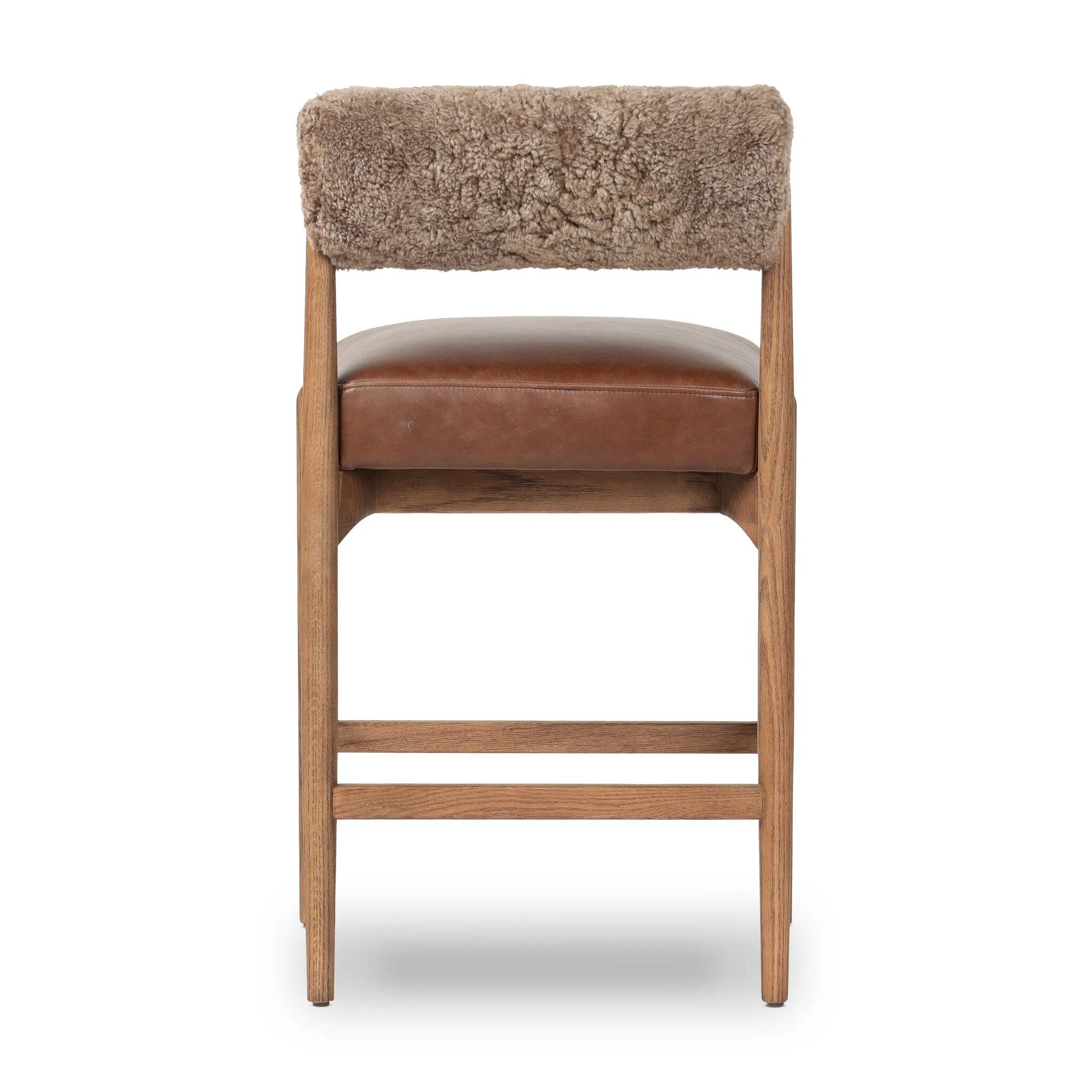 Featuring Jazelle Taupe Shearling Counter Stool by Four Hands at Amethyst Home. Bring mixed materials to the counter. Solid oak, top-grain leather and soft shearling fuse for a playful update to midcentury and Seventies styling. Overall Dimensions: 22.25"w x 25.75"d x 36.50"h. Amethyst Home provides interior design, new home construction design consulting, vintage area rugs, and lighting in the Nashville metro area.