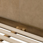 Rounded, chunky dowel legs in an amber oak finish frame the tan top-grain leather headboard of this simple-but-striking bed frame Amethyst Home provides interior design, new home construction design consulting, vintage area rugs, and lighting in the Omaha metro area.