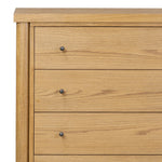 Create storage space in the bedroom with a five-drawer dresser of amber-finished oak. Chunky dowel legs support a tall silhouette and overhang top, all finished out with simple gunmetal hardware Amethyst Home provides interior design, new home construction design consulting, vintage area rugs, and lighting in the Washington metro area.