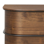 Dark brown walnut is aesthetically shaped with fluid, rounded corners on a ski leg base. The seamless design features six spacious drawers with metal bar hardware that runs along the tops of the drawers Amethyst Home provides interior design, new home construction design consulting, vintage area rugs, and lighting in the Alpharetta metro area.