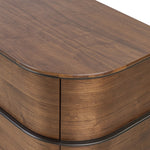 Dark brown walnut is aesthetically shaped with fluid, rounded corners on a ski leg base. The seamless design features six spacious drawers with metal bar hardware that runs along the tops of the drawers Amethyst Home provides interior design, new home construction design consulting, vintage area rugs, and lighting in the Calabasas metro area.