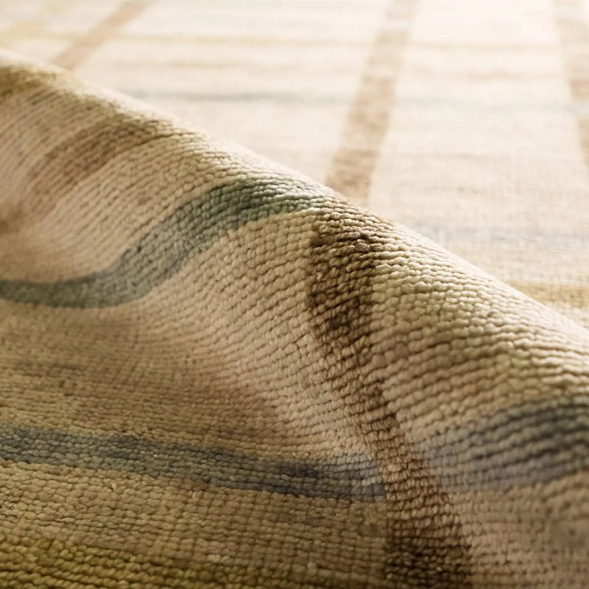 Featuring Raza Hand-Knotted Rug by Jaipur Living at Amethyst Home. The Raza design reinvents the timeless plaid pattern, fusing classic charm with a modern edge. Soft beige tones, punctuated by a blue accent, elevate any mid-century modern space. Handcrafted from naturally stain-resistant wool, this rug handles medium-traffic areas, kids, and pets with eas. Amethyst Home provides interior design, new home construction design consulting, vintage area rugs, and lighting in the Alpharetta metro area.