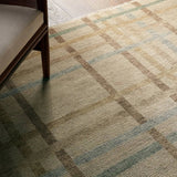 Featuring Raza Hand-Knotted Rug by Jaipur Living at Amethyst Home. The Raza design reinvents the timeless plaid pattern, fusing classic charm with a modern edge. Soft beige tones, punctuated by a blue accent, elevate any mid-century modern space. Handcrafted from naturally stain-resistant wool, this rug handles medium-traffic areas, kids, and pets with ease. A . Amethyst Home provides interior design, new home construction design consulting, vintage area rugs, and lighting in the Tampa metro area.