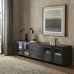 Featuring Toni Worn Black Oak Media Console by Four Hands at Amethyst Home. Grand-scale with a wide, low profile. Glass doors bookend central wood drawers, balancing display and concealed storage. Worn black finish highlights clean lines, anchoring modern spaces with understated impact.Overall Dimensions: 92.00"w x 17.00"d x 24.00"hWeight : 179.90 lbsMaterials : Solid Oak, Thi. Amethyst Home provides interior design, new construction, custom furniture, and area rugs in the Newport Beach metro area