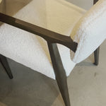 An angular distressed oak frame holds a cushioned seat and back. Upholstered in a soft and subtly fluffy faux shearling. Amethyst Home provides interior design, new home construction design consulting, vintage area rugs, and lighting in the Nashville metro area.