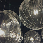 Clear glass spheres float at varying lengths for a statement-making piece. Each globe is individually blown, shaped and sculpted by hand through a one-hour process. The finish on the brass frame is achieved through a specialized process that turns the brass into an almost black hue before the rod is polished smooth. Brass and glass are 98% recyclable. Amethyst Home provides interior design, new home construction design consulting, vintage area rugs, and lighting in the Monterey metro area.