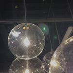 Clear glass spheres dangle at varying lengths for a stunning effect. Each globe is individually blown, shaped and sculpted by hand through a one-hour process. The finish on the brass frame is achieved through a specialized process that turns the brass into an almost black hue before the rod is polished smooth. Brass and glass are 98% recyclable. Amethyst Home provides interior design, new home construction design consulting, vintage area rugs, and lighting in the Alpharetta metro area.