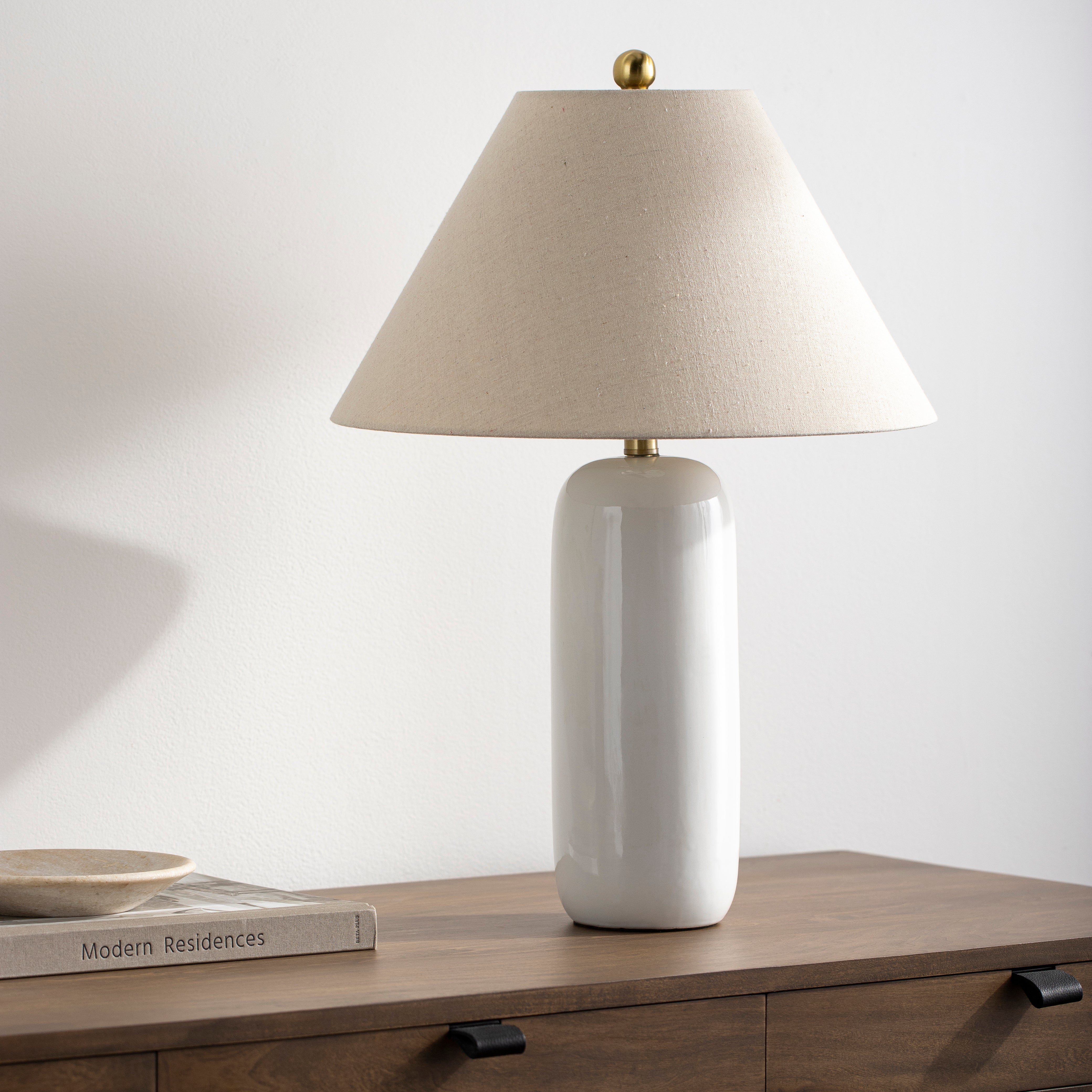Featuring Vespa Table Lamp by Surya at Amethyst Home. A pretty matte white base with a creamy linen shade -- the Vespa lamp is sweet and subtle.  And the top little brass knob is precious!
Overall Dimensions: 26"H x 18"W x 18"D
Switch Type: On/OffNumber of bulbs: 1E-26/60 WUL CUL Certified.  Amethyst Home provides interior design, new home construction design consulting, vintage area rugs, and lighting in the Miami metro area.
