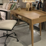 With dramatically tapered legs and a slender silhouette, this Armstrong Desk - Burnished Oak is made of light-burnished oak and places a femme, functional twist on mid-century styling. Dual drawers plus an open center cubby for handy office supply storage.  Overall Dimensions: 55.50"w x 27.00"d x 32.00"h