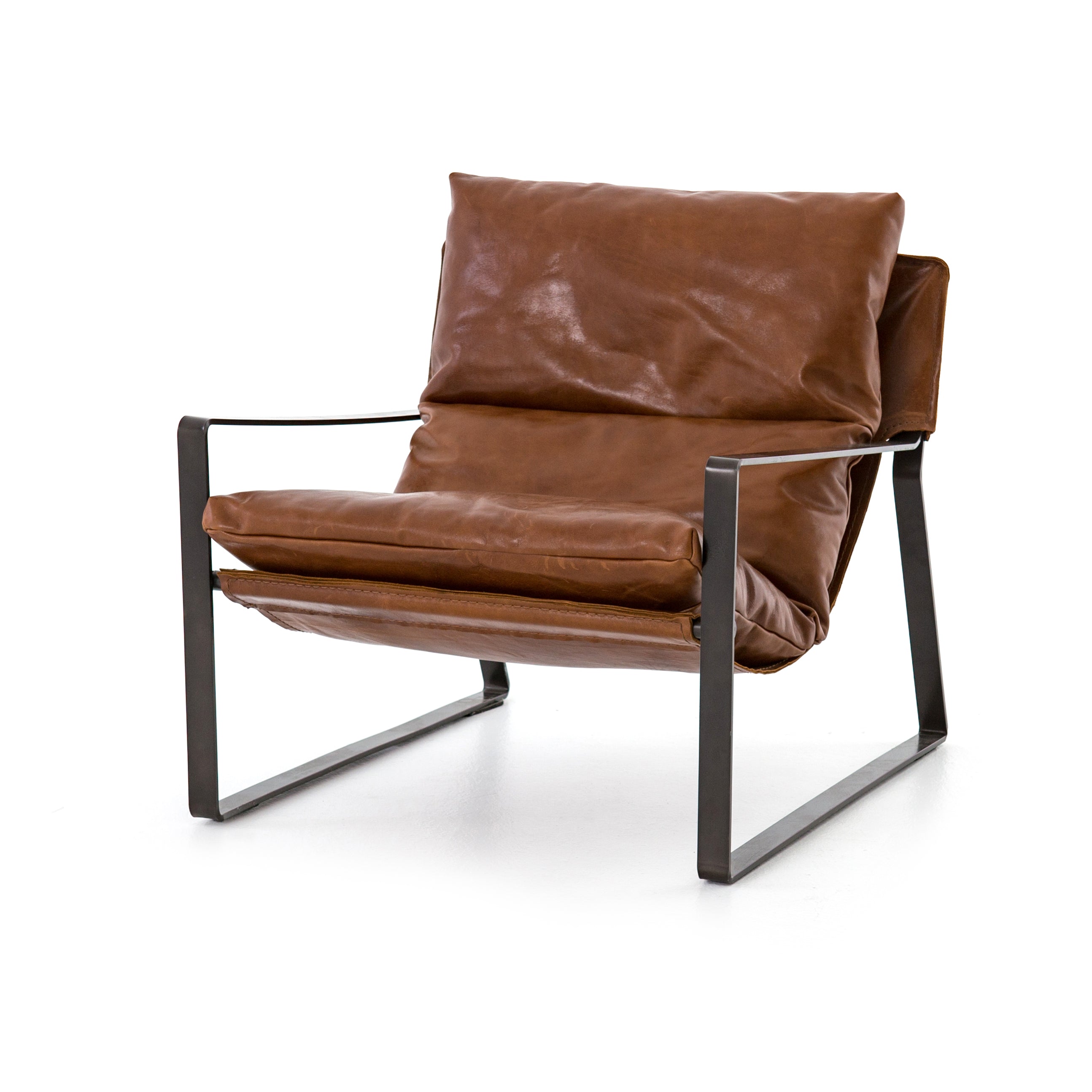 Featuring Emmett Sling Chair - Leather by Four Hands at Amethyst Home. Super stylish, effortlessly cool. Sling-style seating of tobacco-toned leather sits low and curved for a fresh take on a throwback form. Slim, gunmetal-finished iron framing ups the drama factor of an innately hip design.
Overall Dimensions: 29"W x 36"L x 29"HColors: Dakota Tobacco, Gu.  Amethyst Home provides interior design, new home construction design consulting, vintage area rugs, and lighting in the Alpharetta metro area.