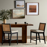 Featuring Antonia  Armless Dining Stool Stool by Four Hands at Amethyst Home. Light-toasted parawood frames a textural inlay of natural cane for a clean, monochromatic look, with seating of performance fabric for smart sensibility. Perfectly sized for the counter, with a brass kick plate for comfort and contrast. Performance fabrics are specially created to withstand spills, stai. Amethyst Home provides interior design, new construction, custom furniture, and area rugs in the Charlotte metro area.