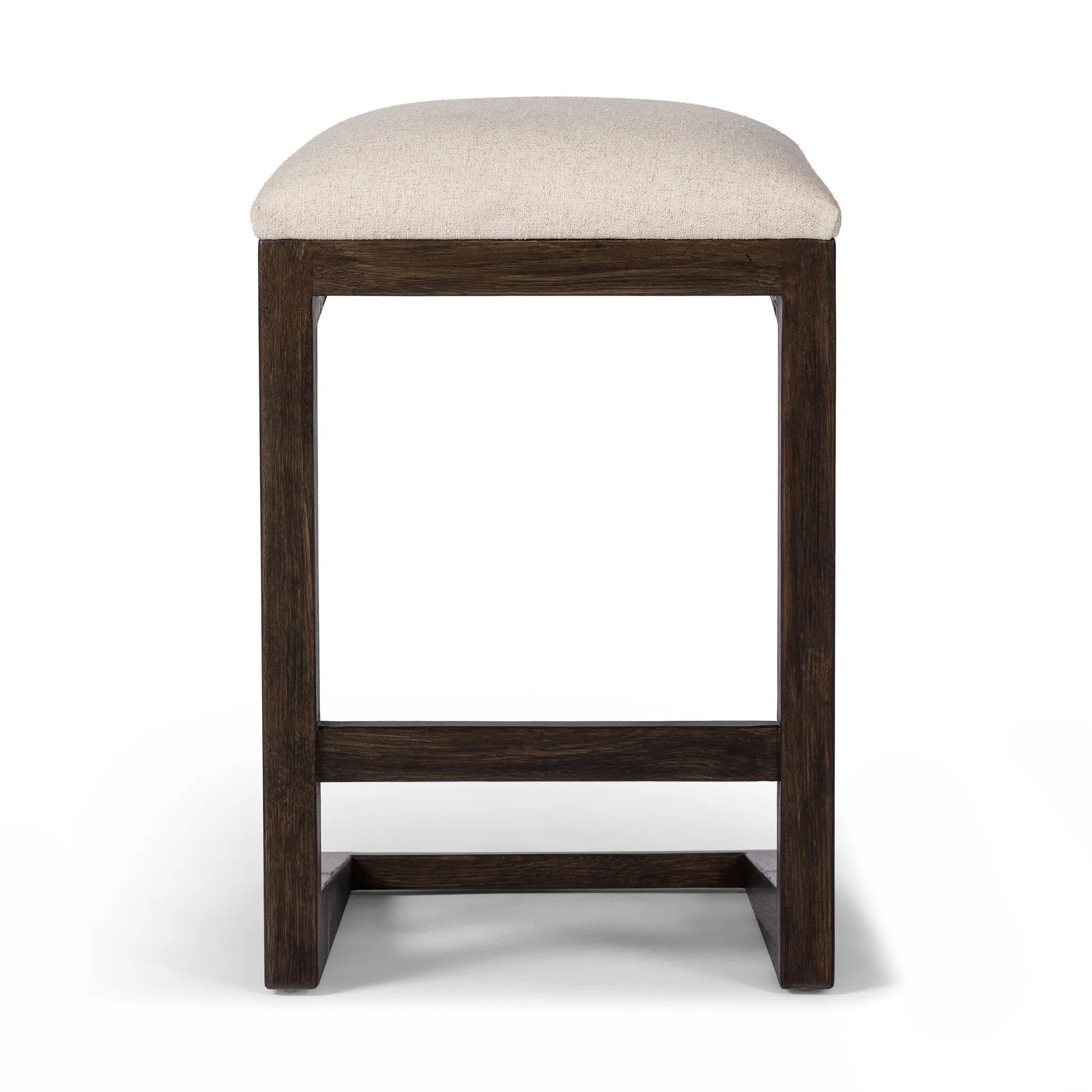 Featuring Finn Sienna Brown Oak Counter Stool by Four Hands at Amethyst Home. A stunner from every angle, this architecturally inspired stool features an angular base crafted from solid oak with two iron rods for added support and visual interest. Seat is upholstered in a linen/cotton/poly blend performance fabric with subtle texture throughout. Performance. Amethyst Home provides interior design, new home construction design consulting, vintage area rugs, and lighting in the Nashville metro area.