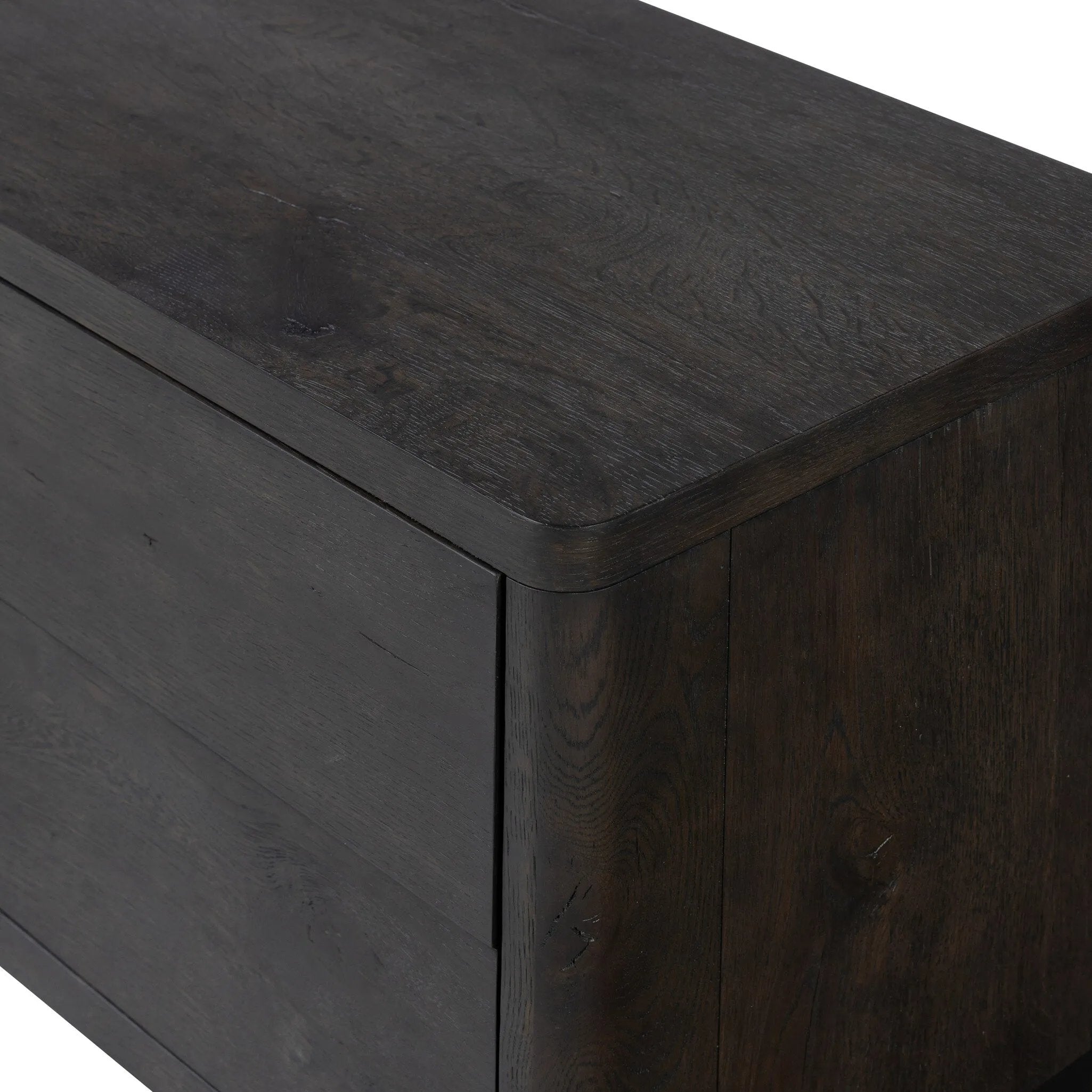 Featuring Noeline Smoked Black Oak Veneer Nightstand by Four Hands at Amethyst Home. Topped with a thick plank of solid oak, this extra-wide nightstand blends modern lines and warm character with two roomy drawers, slightly curved corners, and solid square legs. Seamless drawer fronts have a push-latch mechanism. Made from solid oak and veneer in a smoky black . Amethyst Home provides interior design, new home construction design consulting, vintage area rugs, and lighting in the Tampa metro area.