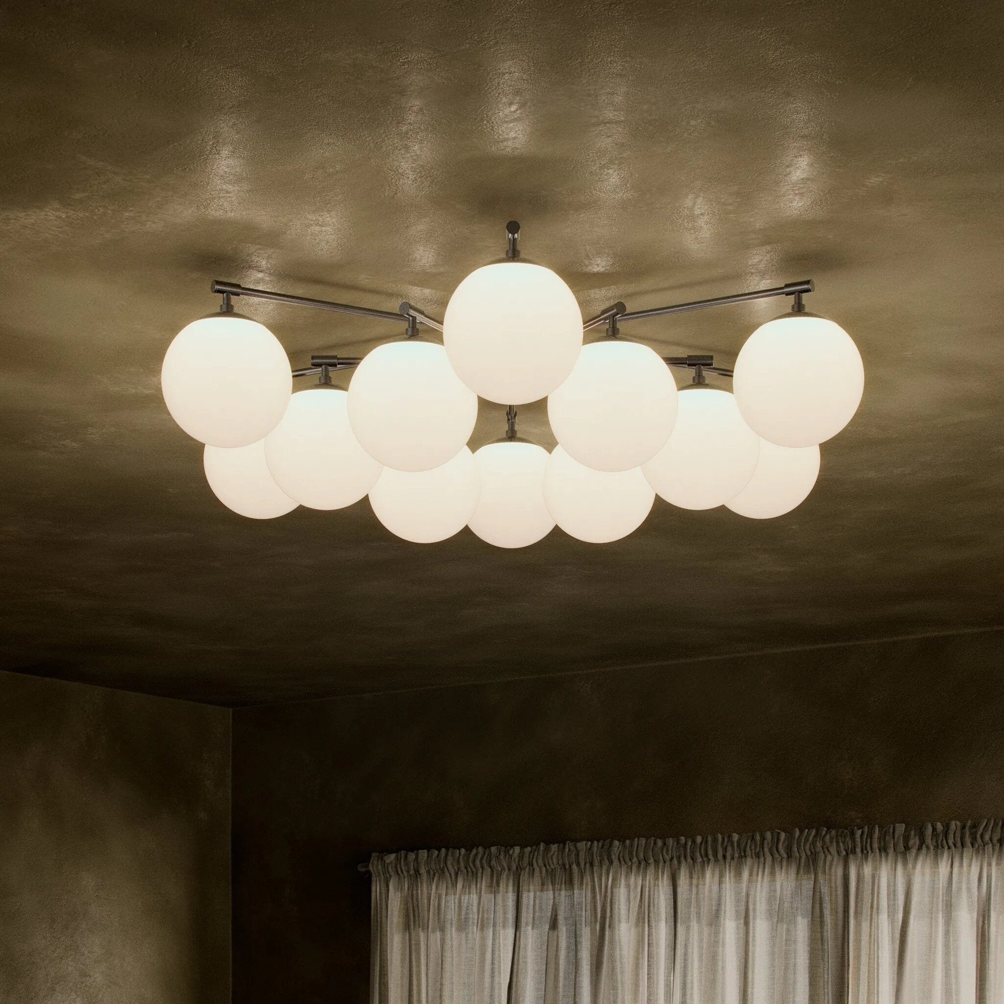 Featuring Orion Black Gunmetal Round Chandelier by Four Hands at Amethyst Home. Matte glass spheres seem to extend and reach across smooth brass rods. Each globe is individually blown, shaped and sculpted by hand through a one-hour process. Matte globes are specially manufactured to evenly diffuse light. The finish on the brass frame is achieved through a s. Amethyst Home provides interior design, new home construction design consulting, vintage area rugs, and lighting in the Calabasas metro area.