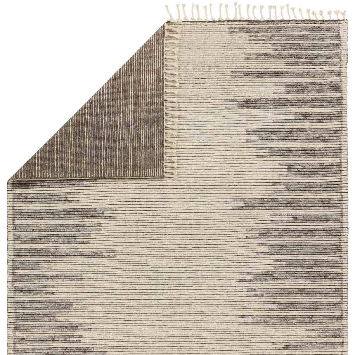 Featuring Alpine Patra Hand-Knotted Rug by Jaipur Living at Amethyst Home. Inspired by textiles from the Tullu region in Morocco, the Patra area rug showcases a linear design in neutral shades of cream, taupe, brown, and gray. This high-piled accent lends warmth and comfort to any space with durable wool hand-knotted onto a cotton foundation. Braided fringe tri. Amethyst Home provides interior design, new home construction design consulting, vintage area rugs, and lighting in the Tampa metro area.