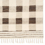 Featuring Desouk Berkshire Hand-Knotted Rug by Jaipur Living at Amethyst Home. The Desouk Berkshire melds modern allure with the global vibes of Morocco. The Berkshire hand-knotted rug showcases a geometric grid pattern with contrasting brown, cream, and tan tones. This handcrafted rug boasts plush, cut wool pile that pairs beautifully with braided tassel deta. Amethyst Home provides interior design, new home construction design consulting, vintage area rugs, and lighting in the Dallas metro area.