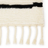 Featuring Desouk Vendace Rug by Jaipur Living at Amethyst Home. The Desouk collection melds modern allure with the global vibes of Morocco. The Vendace hand-knotted rug showcases a geometric linear pattern with contrasting black and cream tones. This handcrafted rug boasts plush, cut wool pile that pairs beautifully with braided tassel details. Perfect for adding warmth to cozy bedrooms a. Amethyst Home provides interior design services, furniture, rugs, and lighting in the Kansas City metro area.