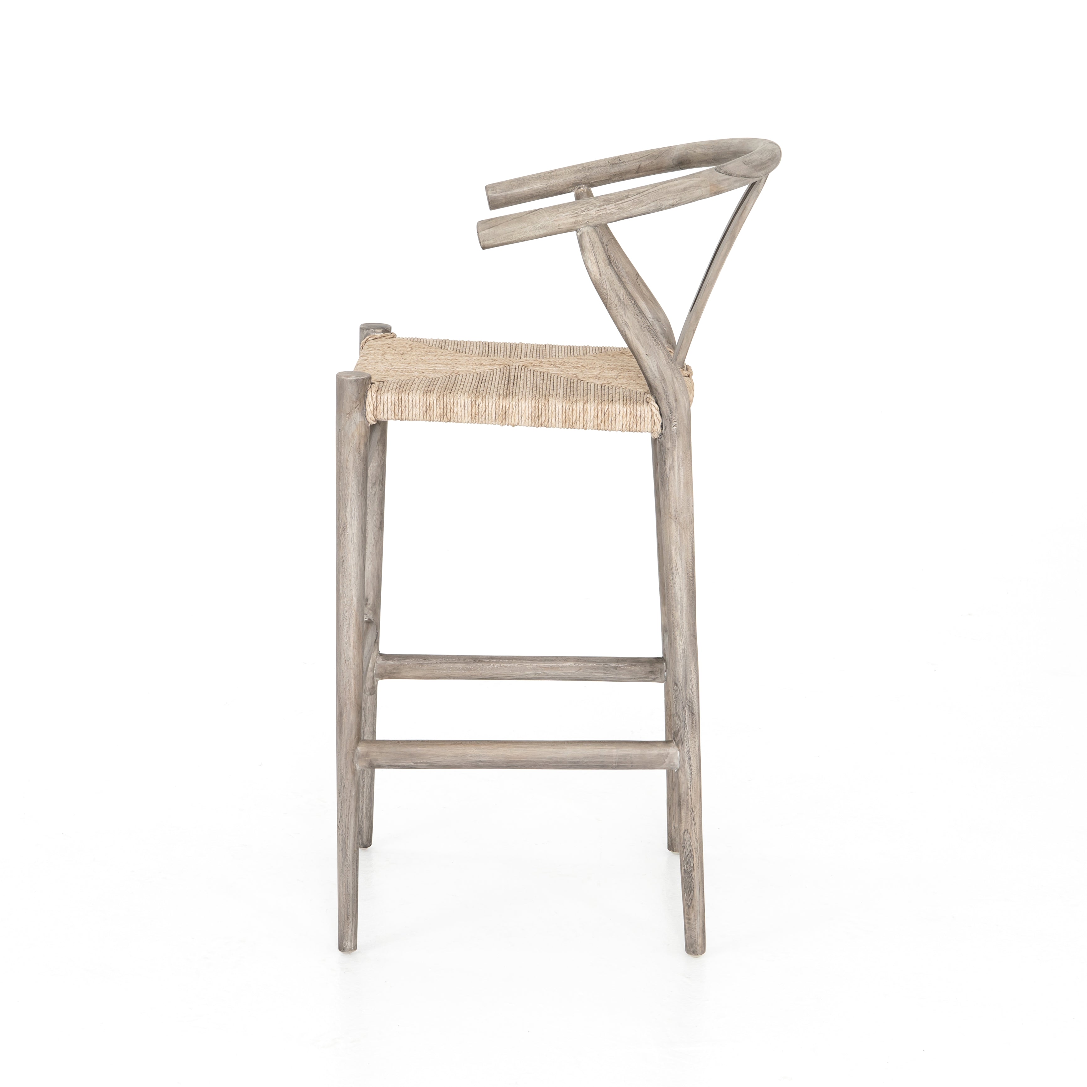 Featuring Muestra Counter + Bar Stool - Weathered Grey by Four Hands at Amethyst Home. Modern curves redefine the classic wishbone-style counter stool. Vintage white all-weather wicker is woven for a dose of fresh texture within weathered grey teak framing. Cover or store indoors during inclement weather and when not in use.
Counter Stool Overall Size: 21.5. Amethyst Home provides interior design, new home construction design consulting, vintage area rugs, and lighting in the Nashville metro area.