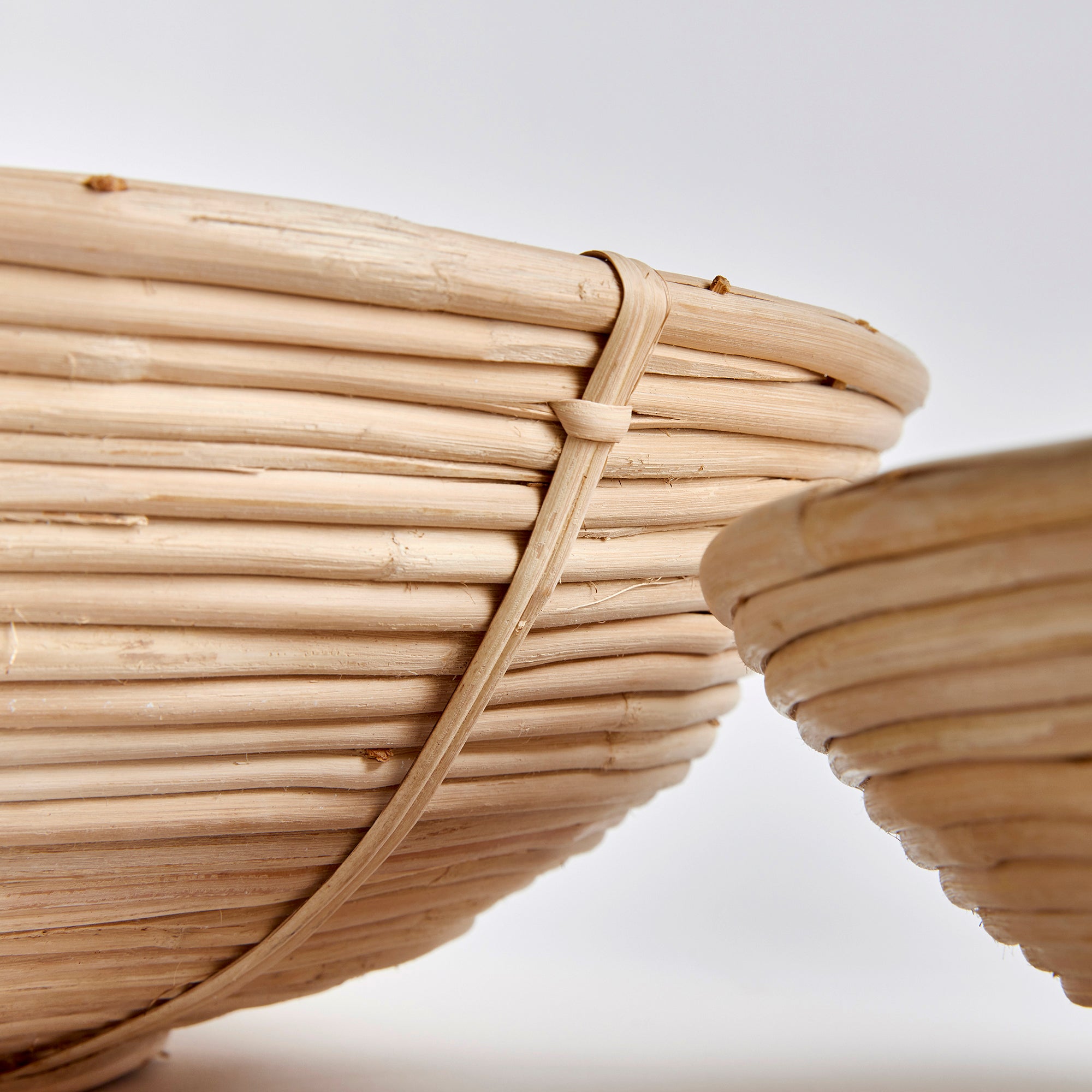 This oversized low bowl cane rattan set of two are stacked, not woven creating a more substantial basket. With a light and refined look, cane rattan is at home in the modern to transitional space. Amethyst Home provides interior design, new construction, custom furniture, and area rugs in the Newport Beach metro area.