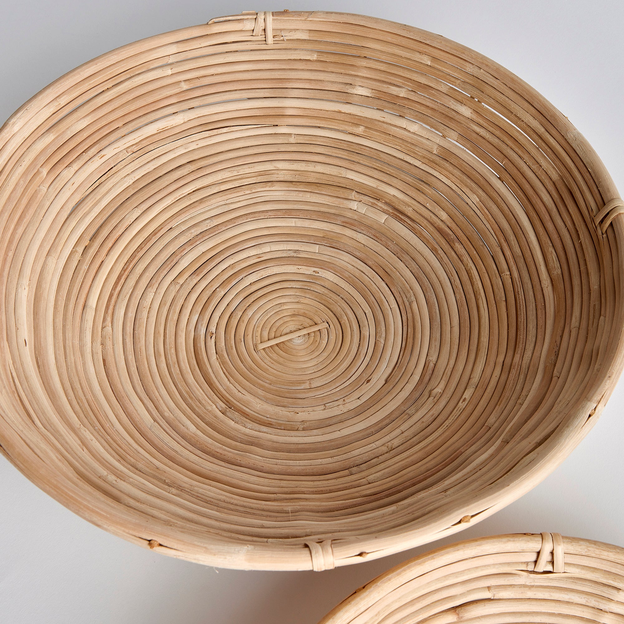 This oversized low bowl cane rattan set of two are stacked, not woven creating a more substantial basket. With a light and refined look, cane rattan is at home in the modern to transitional space. Amethyst Home provides interior design, new construction, custom furniture, and area rugs in the Washington metro area.