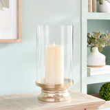 With a traditional silhouette and a snow-on-brass finish, this footed hurricane is at home in the fresh traditional setting. Add a tall pillar candle and enjoy the warm glow. Amethyst Home provides interior design, new construction, custom furniture, and area rugs in the Houston metro area.