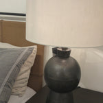 Textured black aluminum forms a shapely base to beautifully complement a white silk shade with this Kelita Table Lamp - Textured Black Alu. A beautiful lamp to place next your bed, sofa, or other area needing extra light.   Overall Dimensions: 16.00"w x 16.00"d x 25.00"h