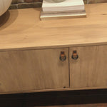This Isador Media Console - Dry Wash Poplar is clean, bright and dreamy. Solid dry-washed poplar forms a clean-lined media console with dovetail joinery plus iron and leather hardware, for a fresh look to any living room.  Ample shelving + rear cut outs for cord management brings this to the next level!