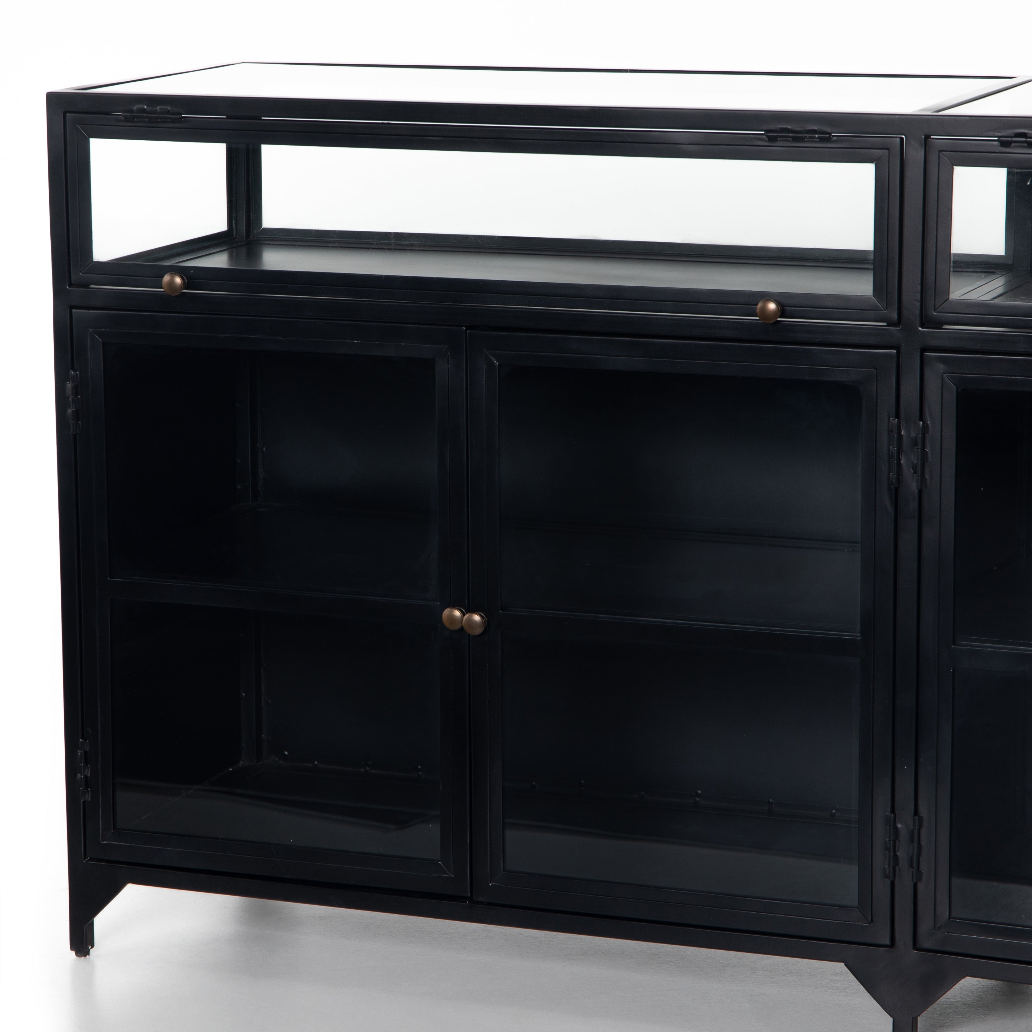 Featuring Shadow Box Sideboard - Black by Four Hands at Amethyst Home. This Shadow Box Sideboard gives your inner collector a place to play. Store prized possessions behind clear glass fronts, with black-finished metal casing and brass hardware for contrast.
Overall Dimensions: 70"W x 17.25"L x 35"H
Colors: Black, Weathered Bronze, Clear Glass, Tempered G.  Amethyst Home provides interior design, new home construction design consulting, vintage area rugs, and lighting in the Washington metro area.