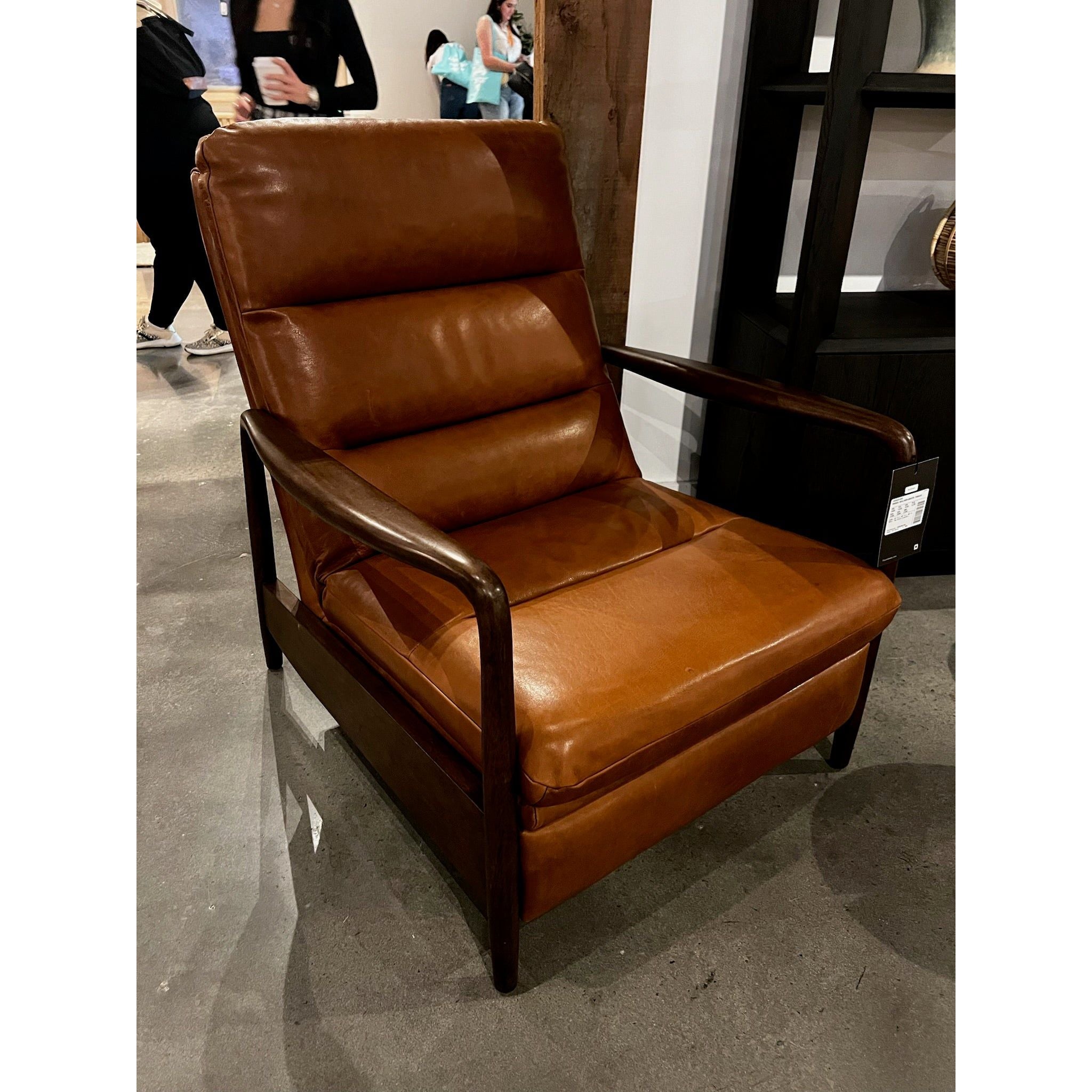A sleek seat with hidden push-back reclining functionality. This midcentury-inspired recliner features wide chunky channeling paired with slim paddle arms and a tapered wood frame. Designed with a high seat and high back for extra comfy support. Upholstered in a timeless tobacco-hued leather made in a family-owned tannery in Thailand. Amethyst Home provides interior design, new home construction design consulting, vintage area rugs, and lighting in the Alpharetta metro area.